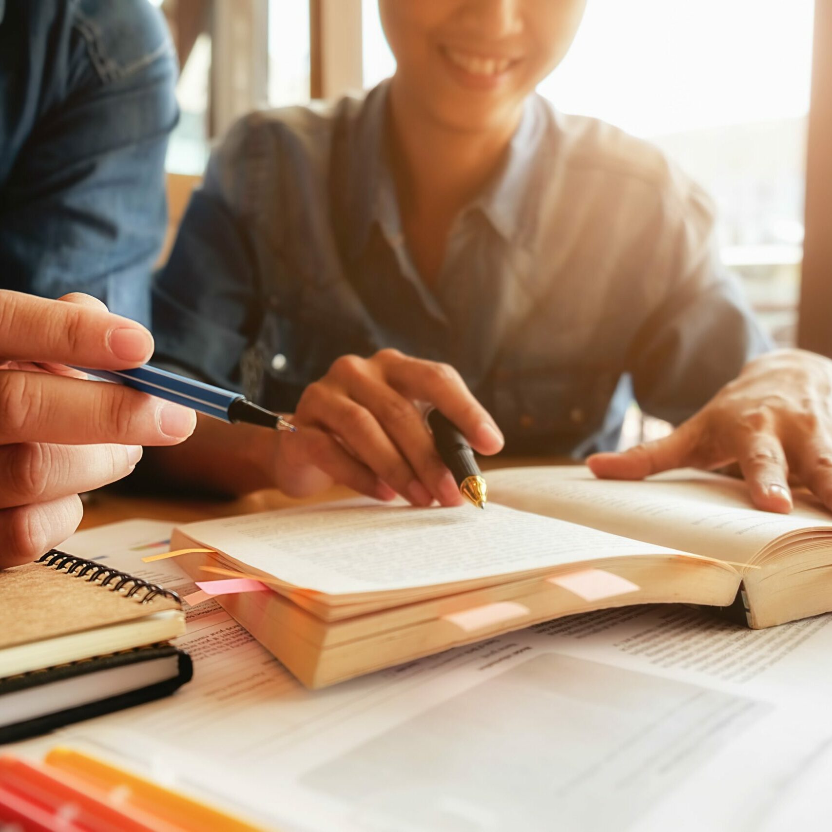 education-concept-student-studying-and-brainstorming-campus-concept-close-up-of-students-discussing-their-subject-on-books-or-textbooks-selective-focus-min